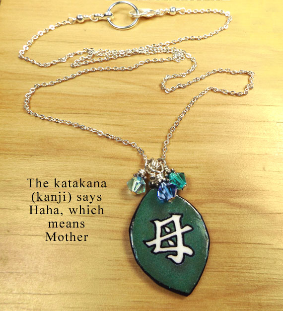 lacquered paper green necklace with the japanese kanji that says Mother