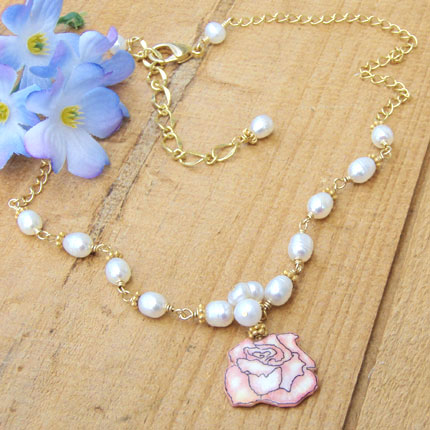 lacquered paper pink rose pendant paired with a cluster of small white pearls and handlinked pearls on a golden chain