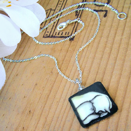 black and white sleeping cat pendant on silver plated chain