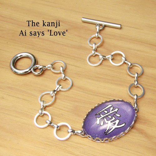 silver plated chain bracelet with glass and paper oval centerpiece that says Ai or Love in Japanese kanji... shown in purple... custom colors available