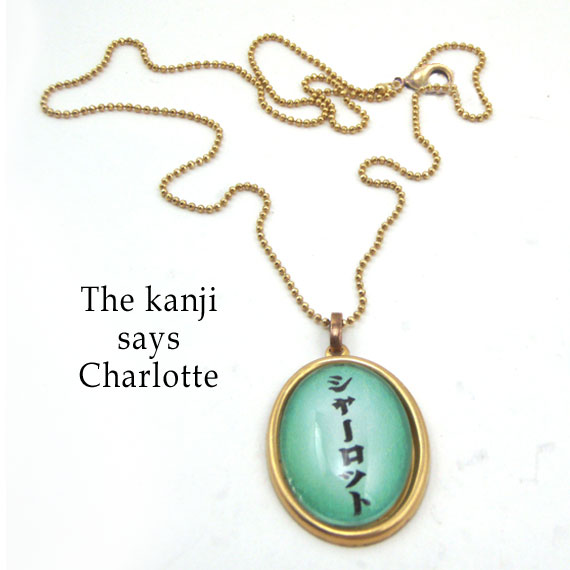 personalized kanji necklace that says Charlotte in Japanese kanji...oval pendant is shown in soft green with black katakana