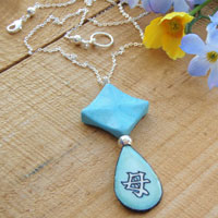 Lacquered paper turquoise teardrop pendant with aqua howlite and sterling silver. The Japanese kanji pendant says Mother.