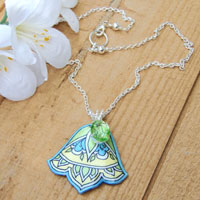 vintage peridot glass jewel and art deco style lacquered paper pendant on a silver plated chain
