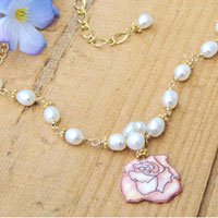 laquered paper pink rose pendant and white freshwater pearl cluster on a golden chain necklace
